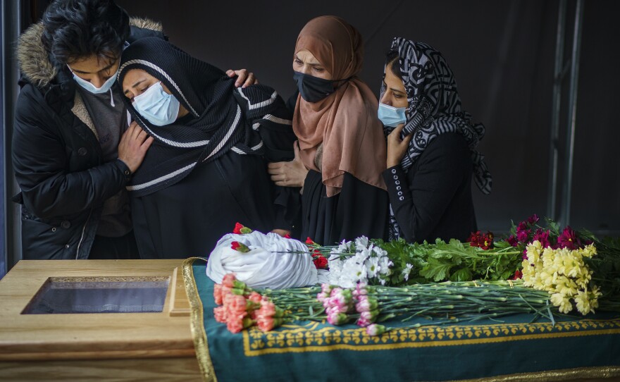 Family members pay their respects next to the body of a close relative, who died from COVID-19, during the coronavirus pandemic lockdown at Manchester Central Mosque in Manchester, U.K., on Feb. 24, 2021.