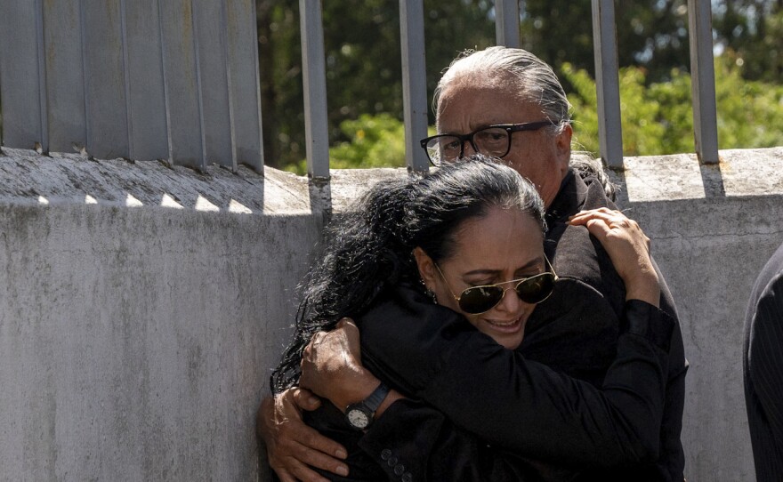 Lorena Villavicencio, sister of slain presidential candidate Fernando Villavicencio, embraces her husband outside the morgue where her brother's body is being held, in Quito, Ecuador, Thursday, Aug. 10, 2023.