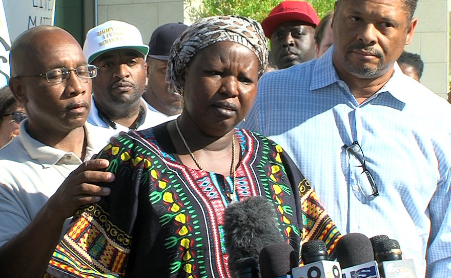 Agnes Hassan, who said she is a family friend of the man who was shot by an officer, speaks in front of a crowd at El Cajon police station, Sept. 28, 2016.