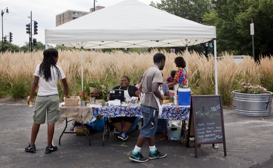 Students from Eastern Senior High School in Washington, D.C., sell vegetables, soaps and salts at the Aya farmers market, July 25, 2015.