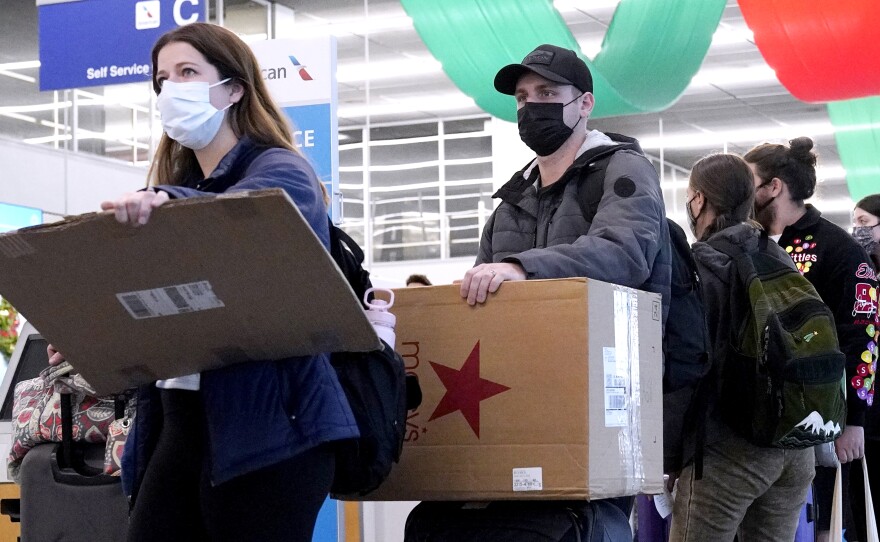 Travelers line up wearing protective masks indoors at O'Hare International Airport in Chicago in December 2021. U.S. District Judge Kathryn Kimball Mizelle voided the national travel mask mandate on Monday.