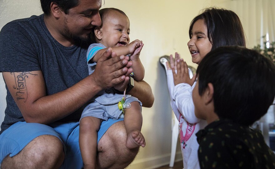 Khisrow Jan plays with children Wais, Shukula and Mirwais (left to right) in this undated image.
