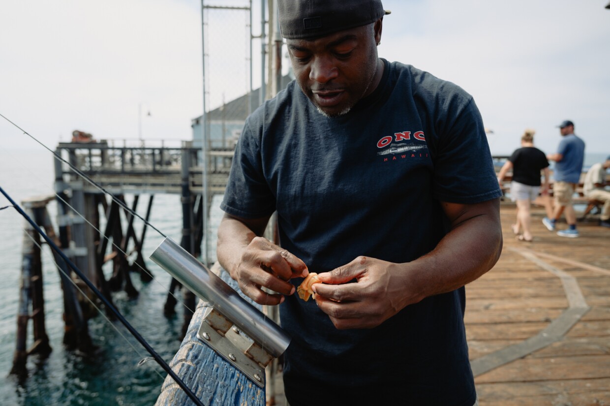 Feddy Johnson of Chula Vista baits one of his hooks with a piece of fresh mussel at the IB Pier in Imperial Beach on September 3, 2024. Johnson has visiting the pier since he was 10 years old and enjoys how close it is and its wooden boardwalk. "It's just a better vibe," he said. "Concrete seems like I'm walking on a sidewalk."