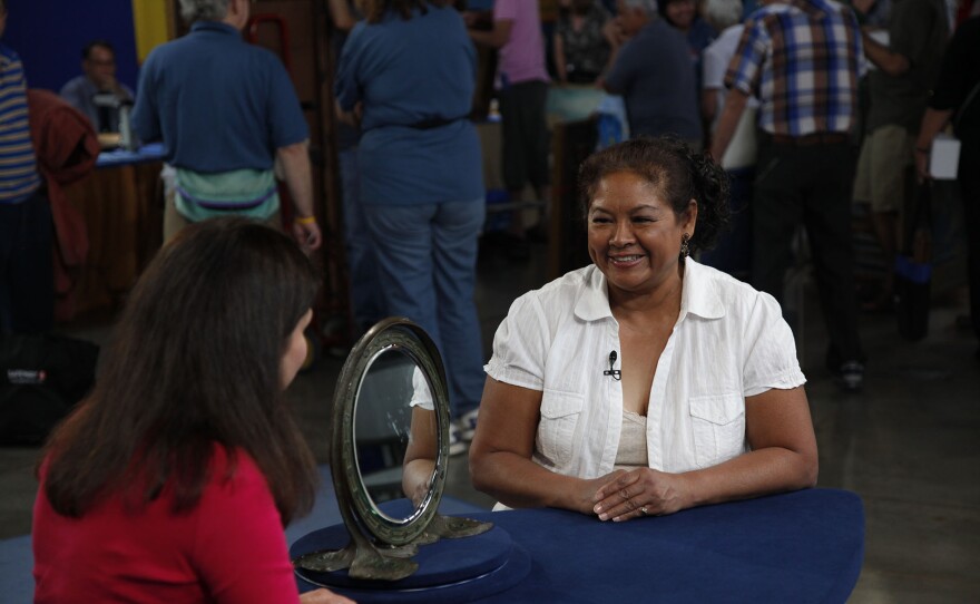 Arlie Sulka (left) appraises a Tiffany Studios peacock mirror, ca. 1905, in Phoenix, Ariz. ANTIQUES ROADSHOW “Vintage Phoenix 2025, Hour 1” airs Monday, October 13 at 8/7C PM on PBS.