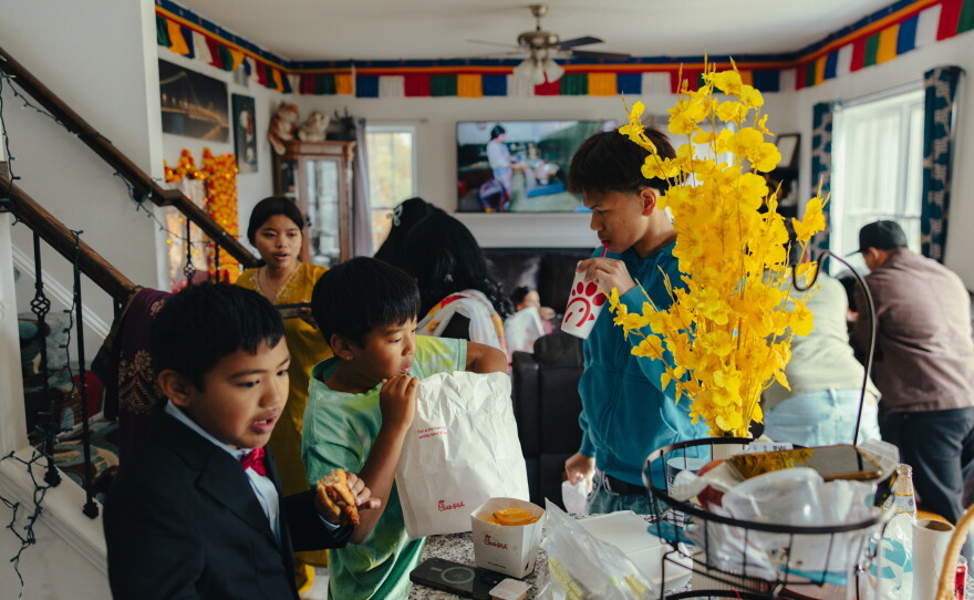 Manju Gurung's cousins and family members, Jason Kharel (from left), Bryan Gurung and Pritam Gurung, sneak in some Chick-fil-A amid holiday festivities in honor of Tihar, the Hindu festival of lights and animals, in Mount Holly Springs, Pa., on Oct. 23, 2025.