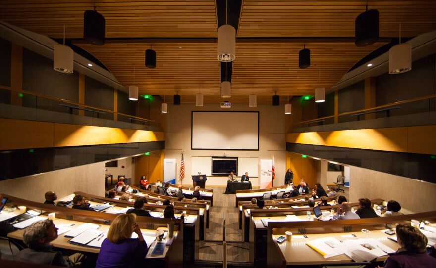 Students are pictured listing to a professor inside a National University classroom, May 2015.
