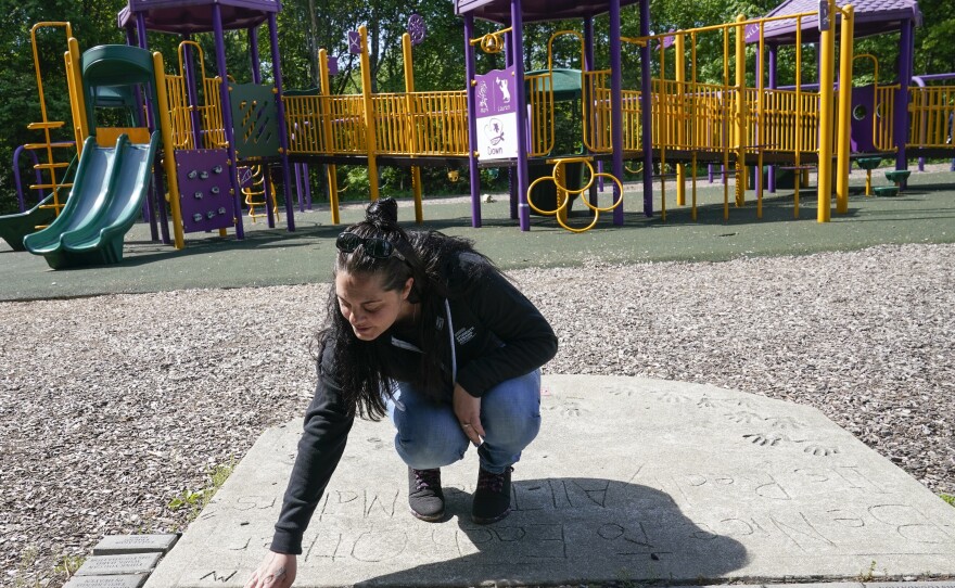 Erica Lafferty, whose mother Dawn Lafferty Hochsprung was killed during the Sandy Hook school shooting in 2012, points out some of the names of friends and family at the playground honoring her mother in Watertown, Conn., Wednesday, May 25, 2022.