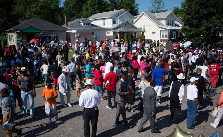 Hundreds gather outside boxing legend Muhammad Ali's childhood home, where mourners wait to pay their respects during a funeral procession in Louisville.