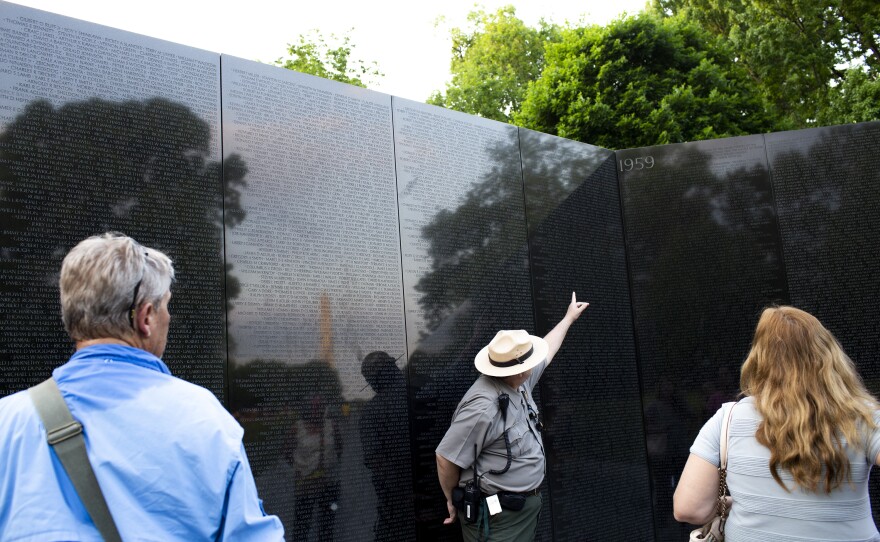 Robert Herendeen, National Park Service ranger, speaks to visitors at the Vietnam Veterans Memorial in Washington, D.C. Rangers like Herendeen have the task of collecting items left at the wall — including human remains.