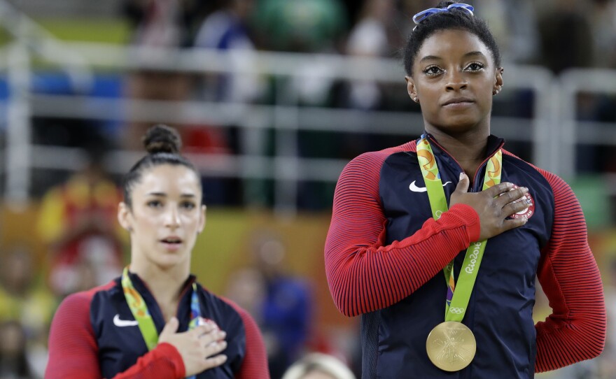 Gold medalist Simone Biles (right) and silver medalist Aly Raisman sing the U.S. national anthem during the medal ceremony for the women's individual all-around on Thursday.