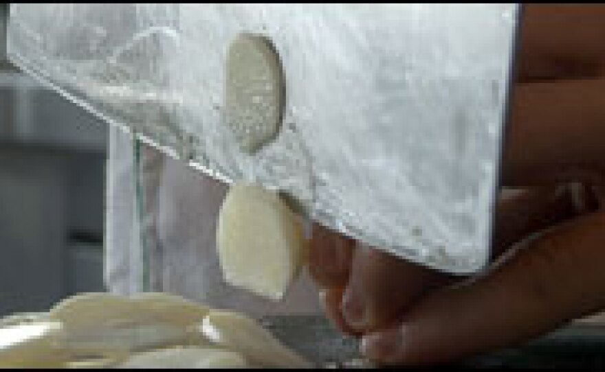 Students at The Sichuan Higher Institute of Cuisine use a cleaver to chop garlic, peel ginger root and squeeze seeds out of chilies.