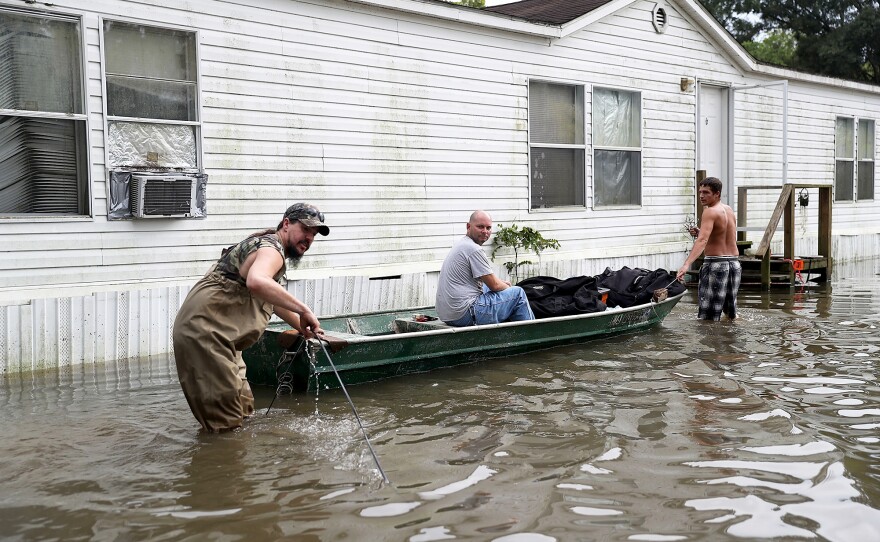 (Left to right) Billy Blazier, Randy Diez Jr. and Tray Blazier checked in on Billy's flooded home on Aug. 18, in Sorrento, La. Many storm sewers nationally simply weren't built to handle the sort of intense rainfall that seems to be happening with greater frequency, flood managers say.