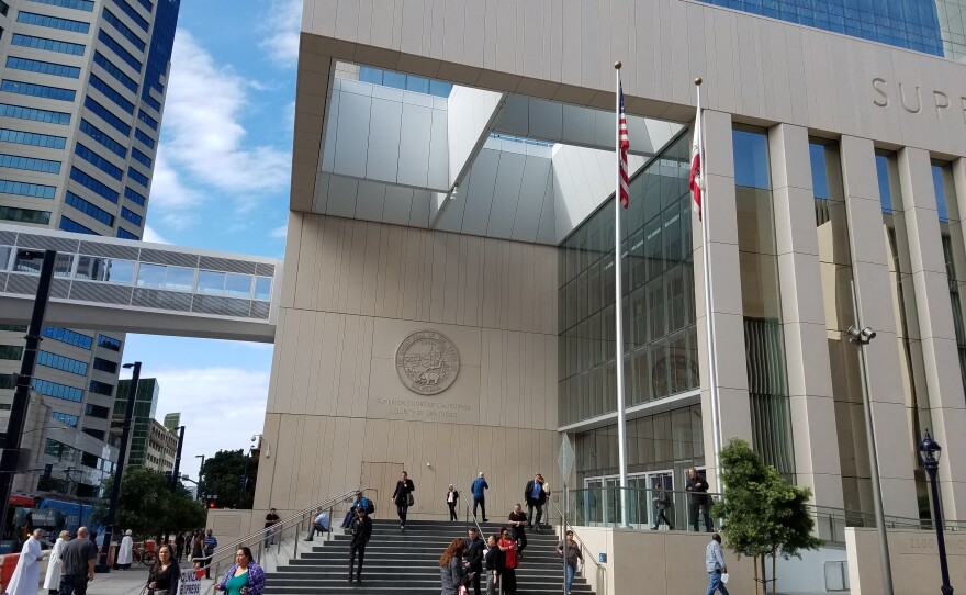 People linger in front of the San Diego Central Courthouse, Feb. 14, 2018.