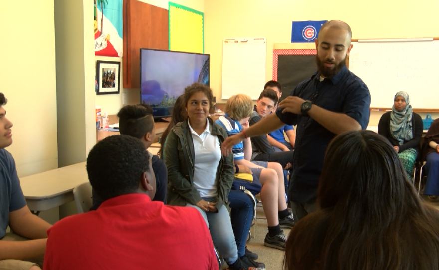 Elijah Gonzalez does the class handshake his students created, Aug. 24, 2016.