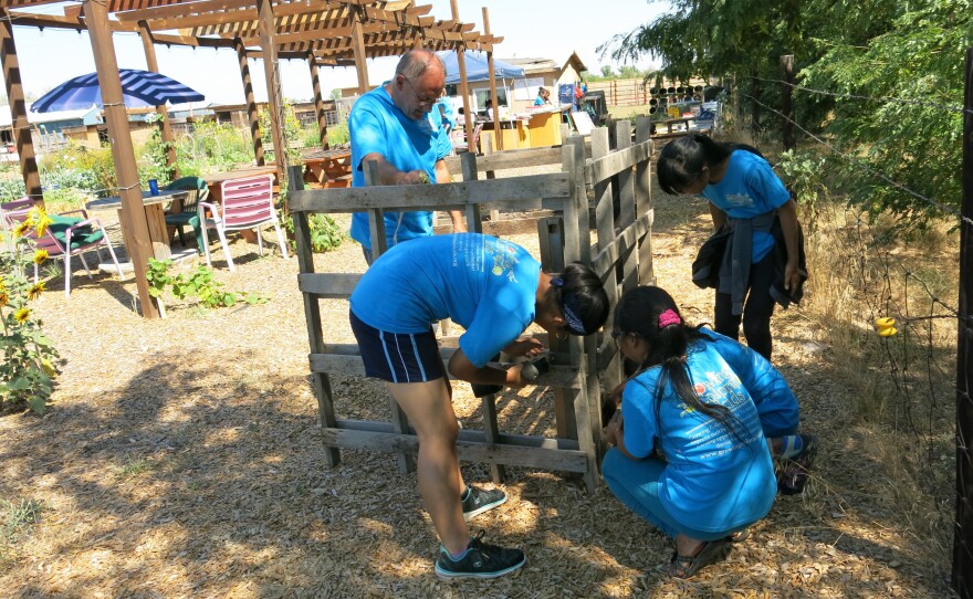 Kids in the program construct a compost bin under the supervision of Chris Lines, whose wife, Denise, founded Growing Colorado Kids.