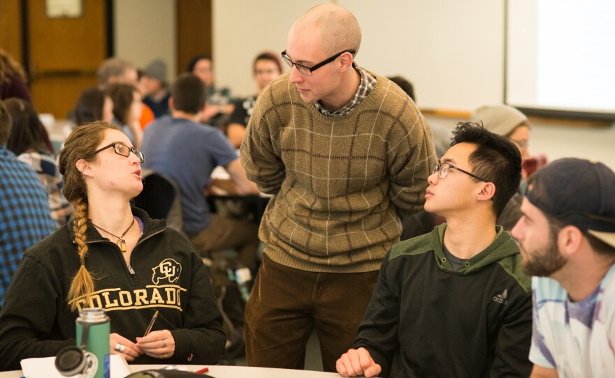 Learning Assistant Michael Byars, standing, talks with, from left, students Anna Eydinova, Aaron Higa, and Austin Reed during an evolutionary biology class.