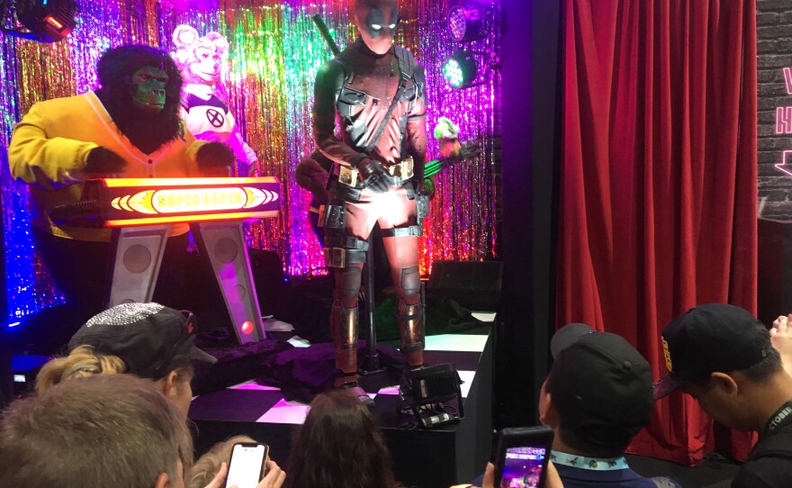 San Diego Comic-Con attendees watch a short music show at the Deadpool 2 booth during Preview Night, July 18, 2018. 