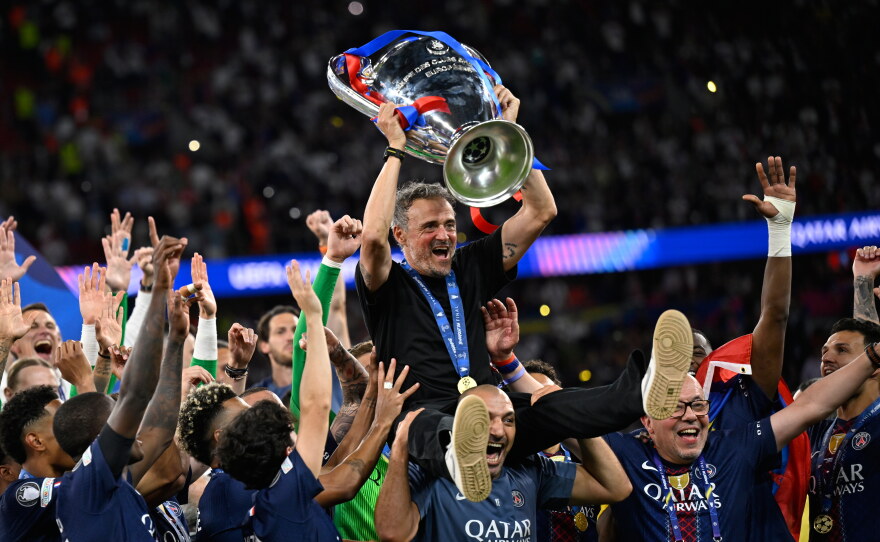 PSG's head coach Luis Enrique, top, celebrates with players after winning the Champions League final soccer match against Arsenal in Budapest, Hungary, Saturday, May 30, 2026.