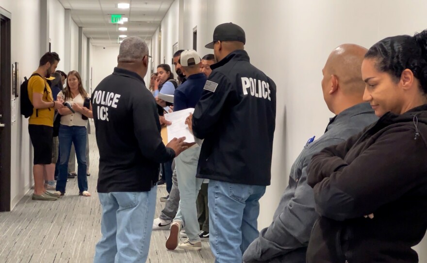 Several Immigration and Customs Enforcement (ICE) agents stand in the hallway of San Diego's immigration court, waiting to detain people as they exit their court hearings on Thursday May 22, 2025.