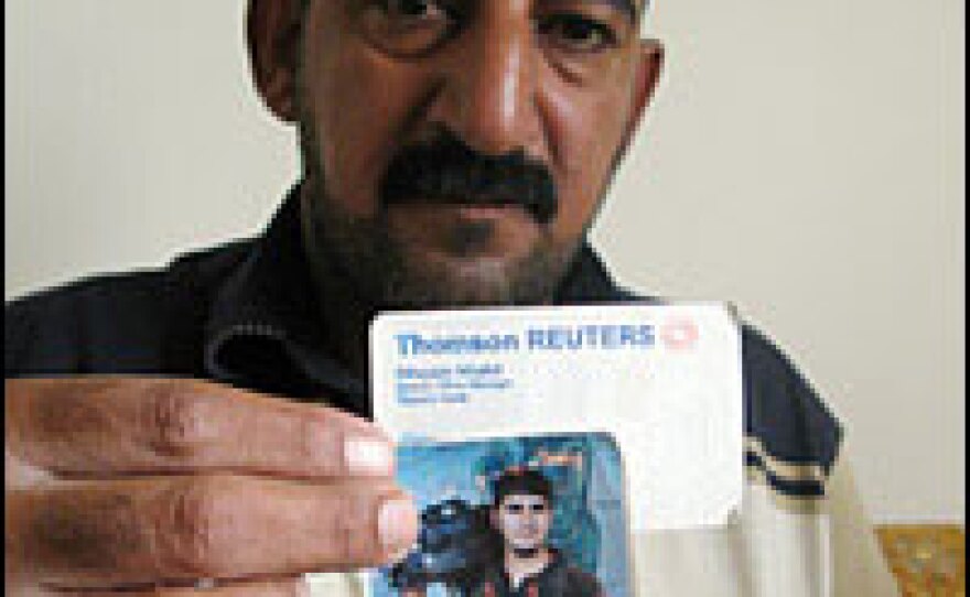 Abu Miriam, holds a photo of his brother, detained Iraqi journalist Ibrahim Jassam.
