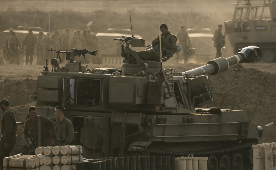 Israeli soldiers sit on an artillery unit near the Israeli border with the Gaza Strip, in Netivot, Israel, Oct. 22, 2023.