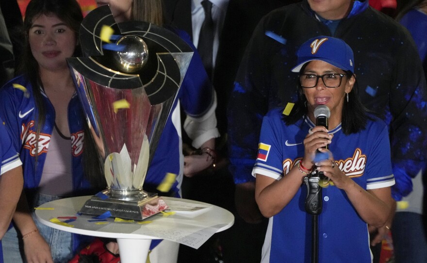 Venezuela's acting President Delcy Rodriguez, right, speaks next to the World Baseball Classic trophy a day after her team's victory over the United States in the championship match, at Miraflores presidential palace in Caracas, Venezuela, Wednesday, March 18, 2026.