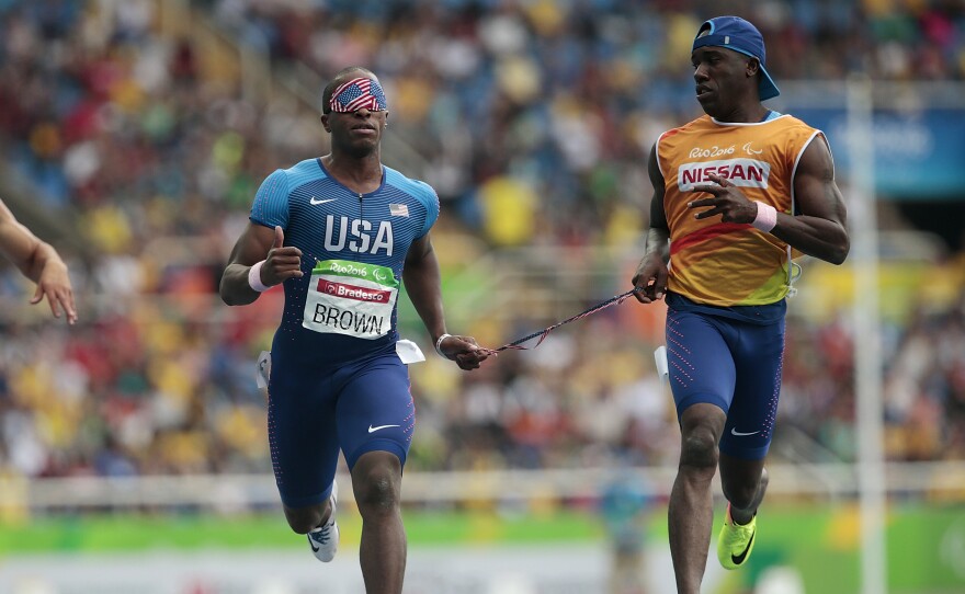 David Brown (left) runs the men's 100 meter T11 round 1 on day 3 of the Rio 2016 Paralympic Games on September 10, 2016 in Rio de Janeiro, Brazil. He is competing in Tokyo with a new partner, Moray Steward.