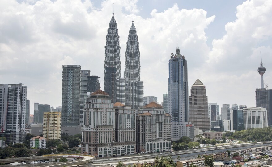 The Petronas Twin Towers rise over Kuala Lumpur, Malaysia's capital. The towers are a prime tourist destination, and buskers often perform there, now with government support.