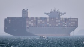 A container ship sits at anchor as a small motorboat passes in the foreground in the Strait of Hormuz off Bandar Abbas, Iran, on May 2.