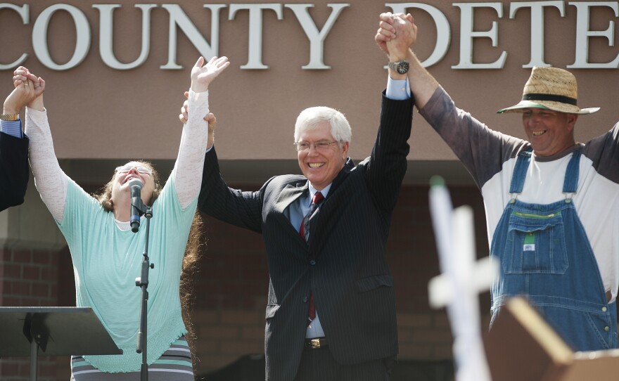 Kim Davis (left) holds her hands in the air with attorney Mat Staver (center) and her husband, Joe Davis, after she was released from jail. She was jailed for her refusal to grant same-sex-marriage licenses.