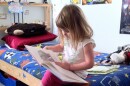Four-year-old Gabriella Anderson spends her free time reading a hardback book in her brothers' bedroom.  