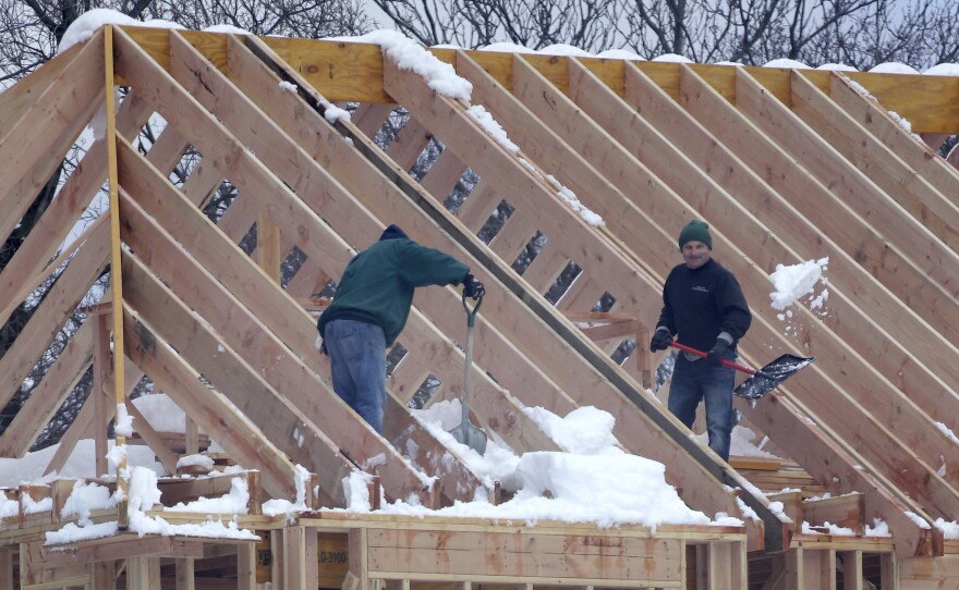 Men shovel snow off the top of a building under construction in Franklin Lakes, N.J., on Thursday. Job growth in February was led by a sharp increase in construction employment.