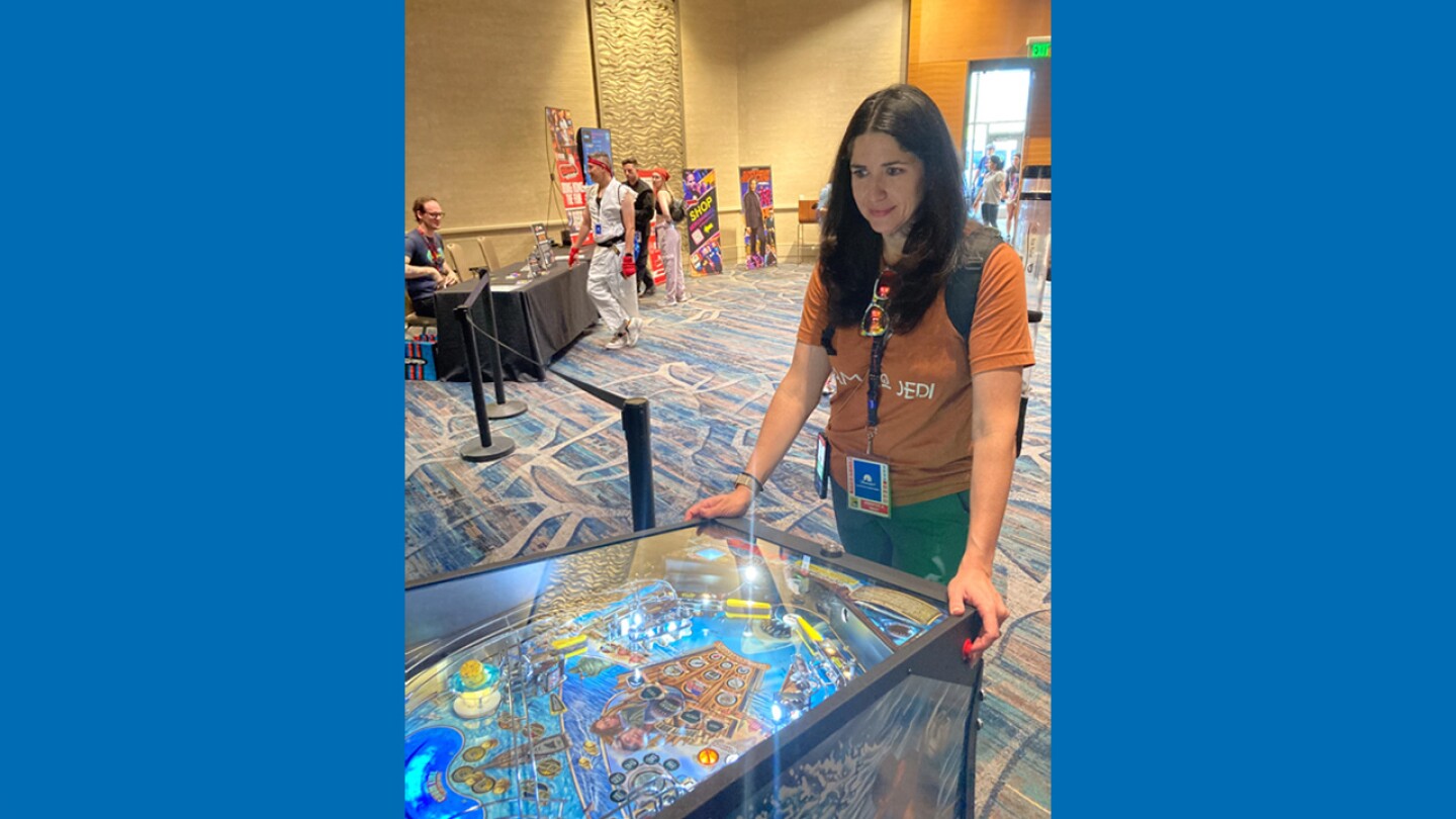 Attendee Jennifer West plays pinball at the Marriott Marquis in the Pacific Ballroom on July 26, 2024.