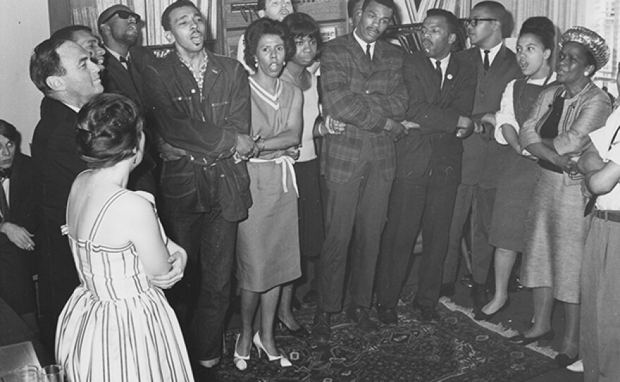 Lorraine Hansberry holds hands and sings with Singer Nina Simone and other activists at a pre-benefit gathering for the Student NonViolent Coordinating Committee (SNCC) in June 1963 in the home of Activist/Singer/Actor Theodore Bikel.