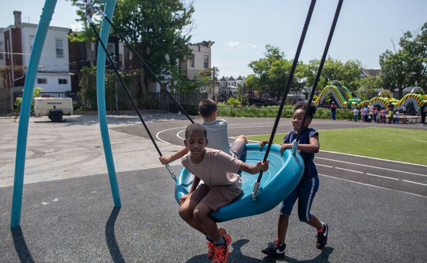 Students play on their new swing in the schoolyard at the Add B. Anderson School. The design features a spongy foundation to help prevent injuries.
