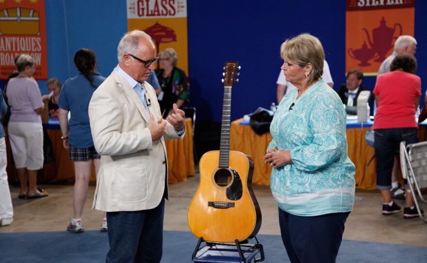 Ken Farmer (left) appraises a guest’s 1944 Martin D-28 Herringbone guitar.