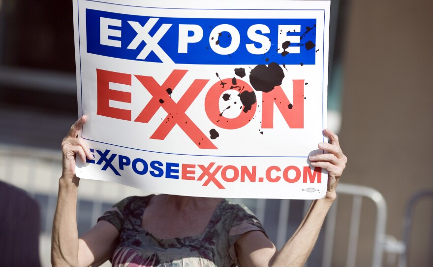 A protester holds a sign outside of the ExxonMobil annual shareholders meeting in Dallas in 2008.