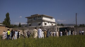 Pakistanis along with international and local media gather outside the compound in the city of Abbottabad where Osama bin Laden was killed during a raid by U.S. special operations forces.