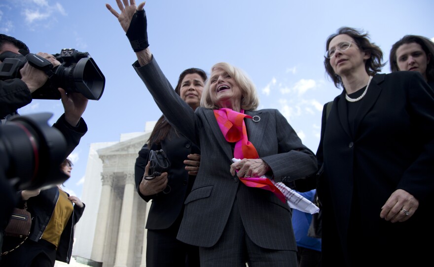 Plaintiff Edith Windsor,of New York, waves to supporters in front of the Supreme Court in Washington on Wednesday, after the court heard arguments on her Defense of Marriage Act (DOMA) case.