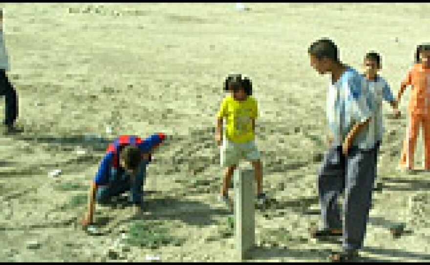 Children run up to a mortar round on the side of a highway as Americans searching for roadside bombs move in to inspect it. The shell turned out to be a dud.