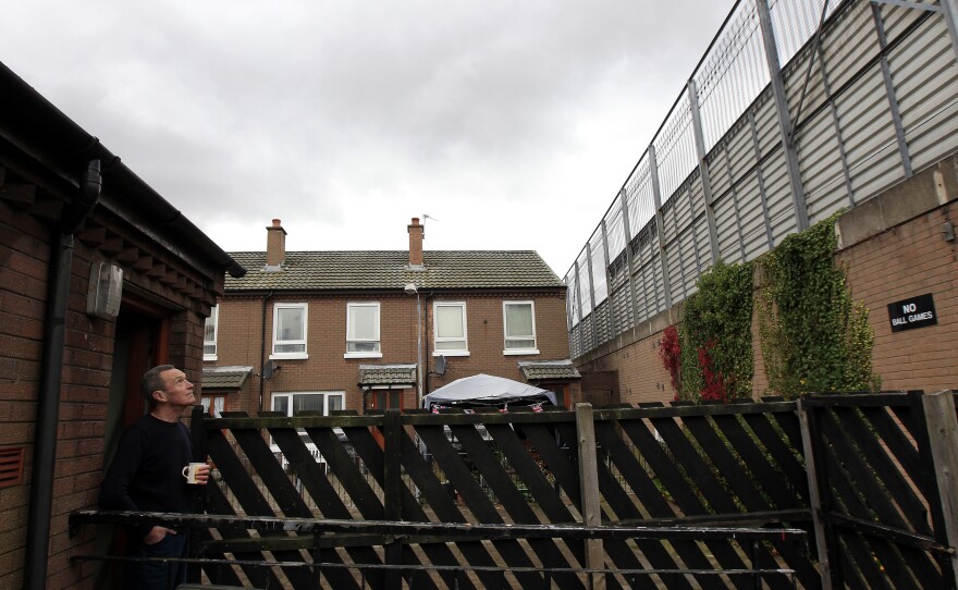 Retiree William Boyd looks at the peace wall that runs along the bottom of his garden in east Belfast, in 2012.