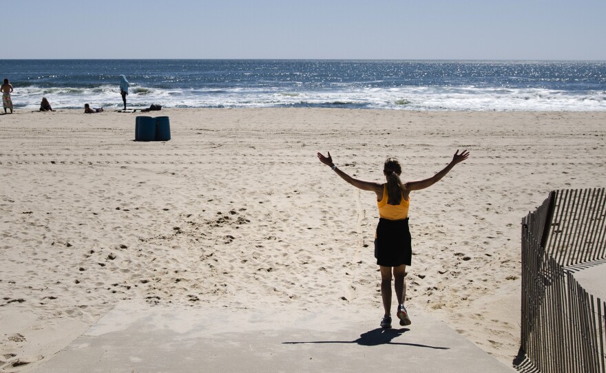 The Jersey Shore is central to the state's identity, Gov. Phil Murphy said Thursday, announcing that all New Jersey beaches can reopen soon. Here, a woman walks on the beach this month in Belmar, N.J.