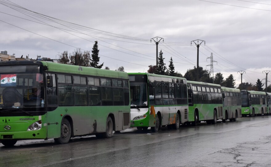 These buses — meant to evacuate civilians leaving from rebel-held areas of Aleppo — sit empty and waiting on Wednesday. Thousands of cold and hungry civilians crowded the streets of Aleppo uncertain of their future after their planned evacuation from the last rebel pocket of the city was delayed.