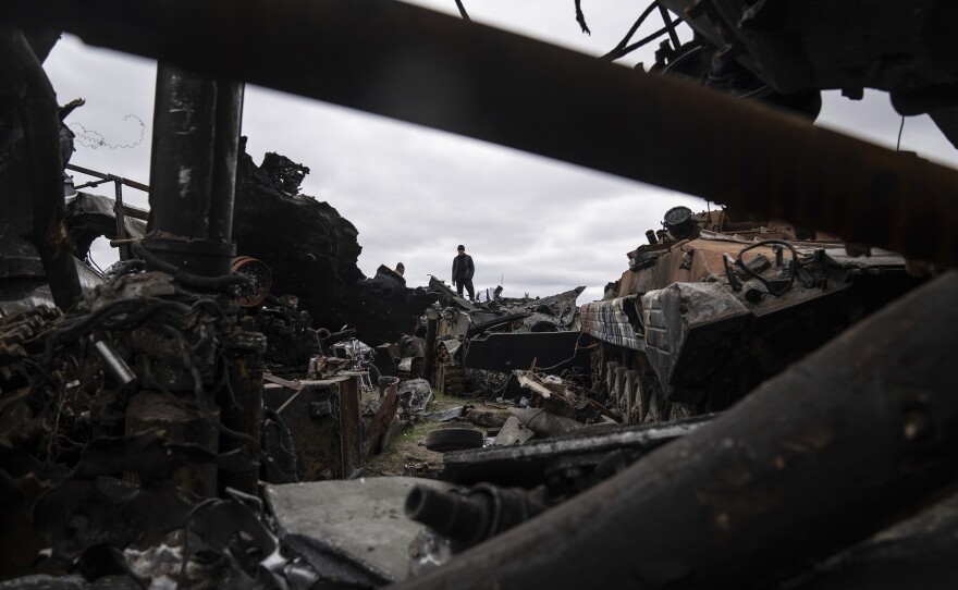 <strong>April 19:</strong> A man stands on top of destroyed Russian armored vehicles in Bucha.
