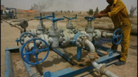An Iraqi worker checks the valves at the Kirkuk oil field. Tuesday, the government of Iraq opens bids from oil companies interested in helping the country increase its oil production.