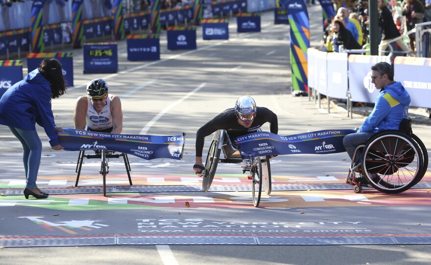 Marcel Hug of Switzerland, right, crosses the finish line first, just ahead of Kurt Fearnley of Australia, in the men's wheelchair division of the 2016 New York City Marathon on Sunday.