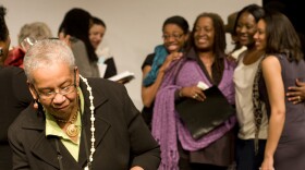 Editor Barbara A. Seals Nevergold signs copies of her book "Go, Tell Michelle" while the actresses who performed in the staged reading of the book get their picture taken in the background. 