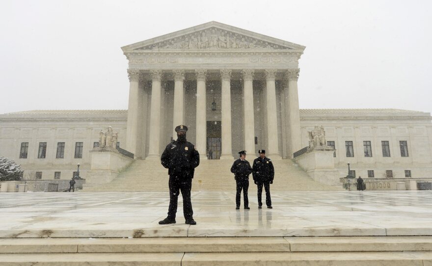 Supreme Court police stand guard during a storm in March.