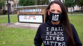 Amy Donofrio stands in front of Robert E. Lee High School in Jacksonville, Fla. She was suspended from teaching duties after she refused to take down a Black Lives Matter flag from outside her classroom.