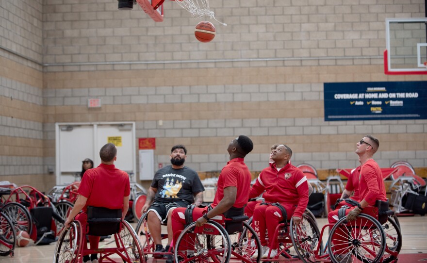 Eight wheelchair basketball players from the Marine Corps team watch the ball swish through the hoop at a gym on Marine Corps Base Camp Pendleton during Warrior Trials practice Wednesday, Feb. 25, 2026.